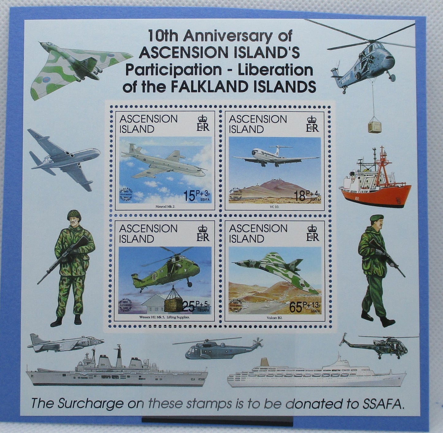 A commemorative stamp sheet celebrating the 10th Anniversary of Ascension Island's participation in the liberation of the Falkland Islands. The sheet features a central 2x2 block of four stamps with military aircraft and soldiers, surrounded by illustrations of military vehicles and ships on a light blue background with a darker blue border.