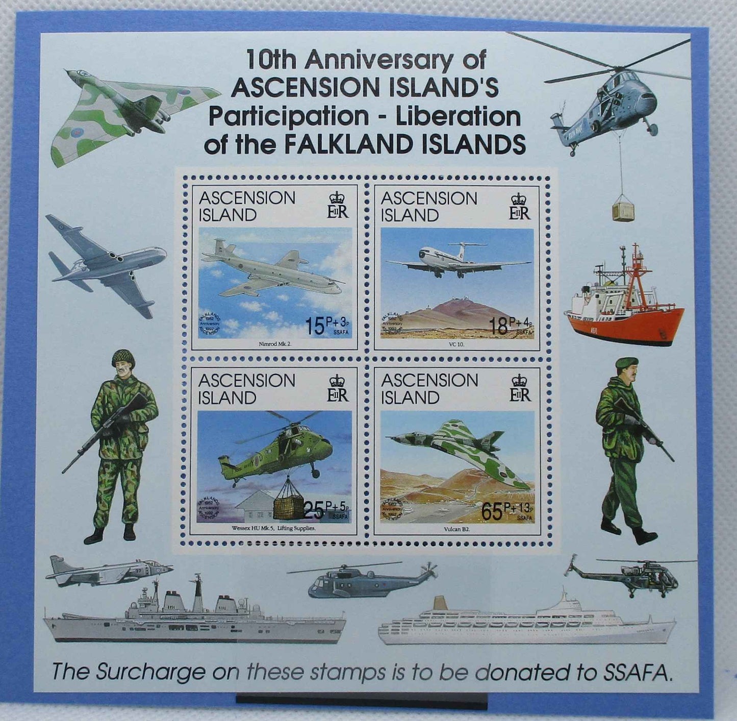 A commemorative stamp sheet celebrating the 10th Anniversary of Ascension Island's participation in the liberation of the Falkland Islands. The sheet features a central 2x2 block of four stamps with military aircraft and soldiers, surrounded by illustrations of military vehicles and ships on a light blue background with a darker blue border.