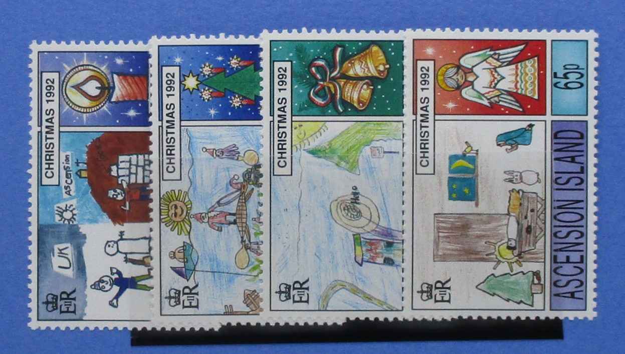 Four vintage Christmas postage stamps from Ascension Island, dated 1992, displayed side-by-side on a black stand against a blue background.