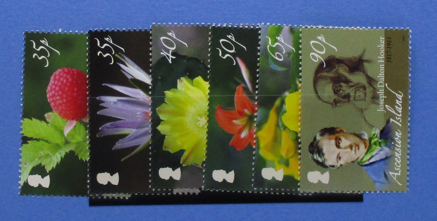 Six vintage British postage stamps from Ascension Island, arranged in a fan shape on a solid blue background. The stamps feature colorful botanical illustrations (raspberry, purple flower, yellow flower, red flower) and portraits of Joseph Conrad, with denominations 35p, 35p, 40p, 50p, 65p, and 90p.