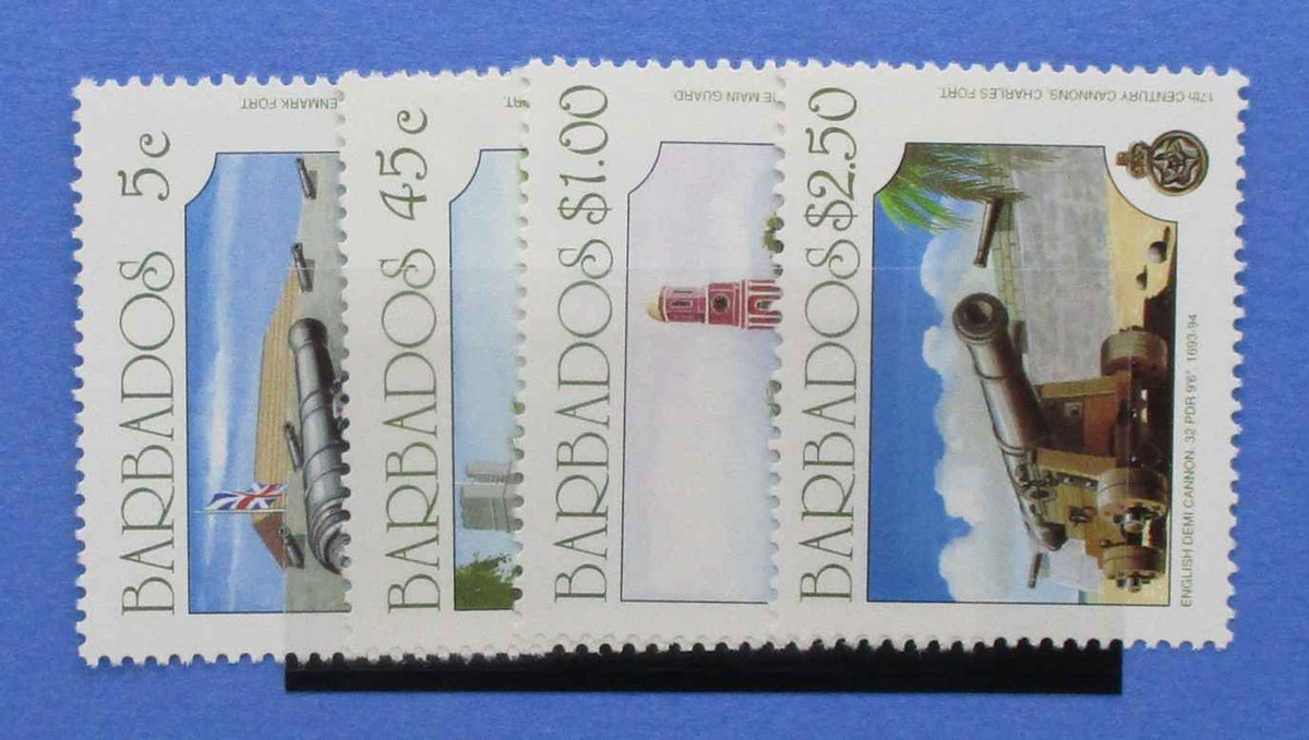 A set of four Barbados postage stamps displayed on a black stand against a solid blue background. The stamps feature historical cannons and architecture, with denominations of 5c, 4.