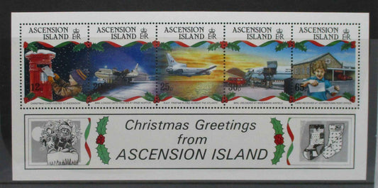 Ascension Island Christmas postage stamp souvenir sheet with five colorful stamps depicting holiday scenes and a white border with 'Christmas Greetings from ASCENSION ISLAND' text and small black-and-white illustrations.