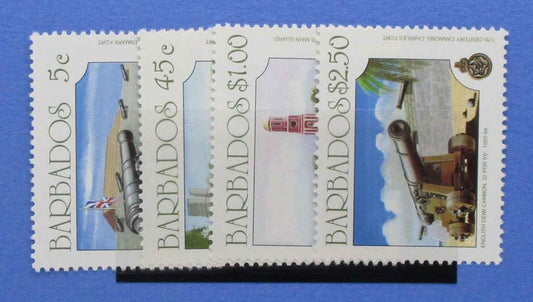 A set of four Barbados postage stamps displayed on a black stand against a solid blue background. The stamps feature historical cannons and architecture, with denominations of 5c, 4.