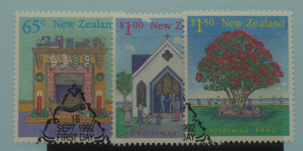 Three New Zealand stamps featuring a fireplace, a church, and a tree with people around it, dated 1992.