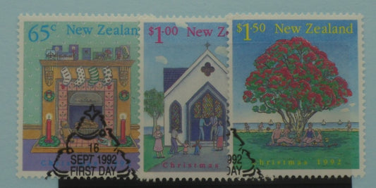 Three New Zealand stamps featuring a fireplace, a church, and a tree with people around it, dated 1992.