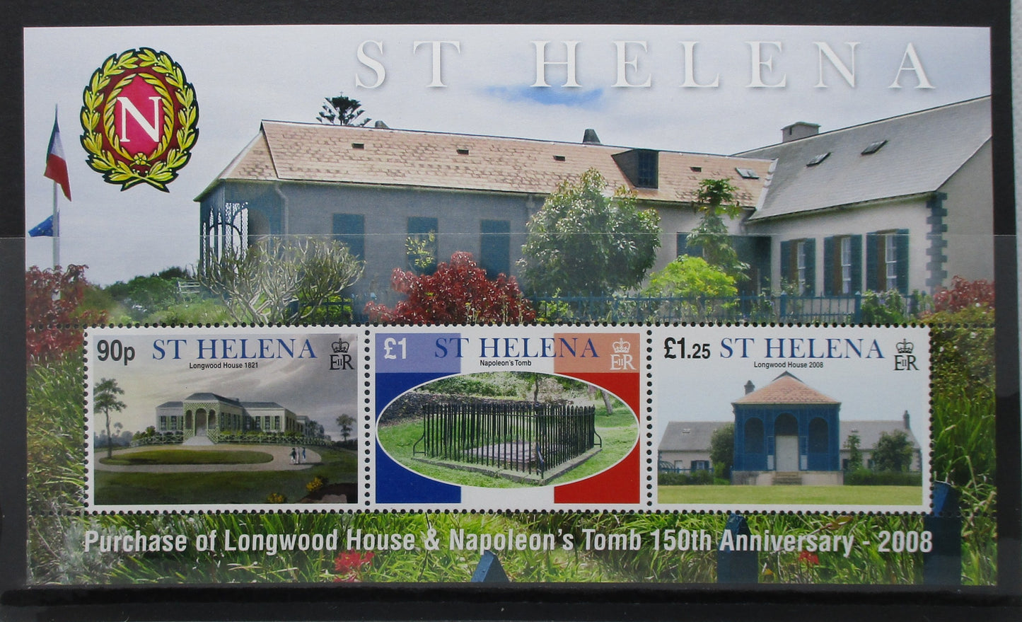 A commemorative St. Helena postage stamp sheet for the purchase of Longwood House and Napoleon's Tomb, featuring three stamps and a large printed background image of the house, with the St.